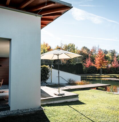 Herbstaufnahme der Private Spa Suite in Geinberg5 mit Blick auf den Badesteg und Naturbadeteich | © Spa Resort Geinberg / Tobi Gast