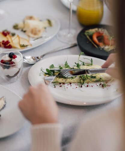 Blonde Frau genießt eine Omelette zum Frühstück im Geinberg5 Restaurant | © Spa Resort Geinberg / Chris Perkles