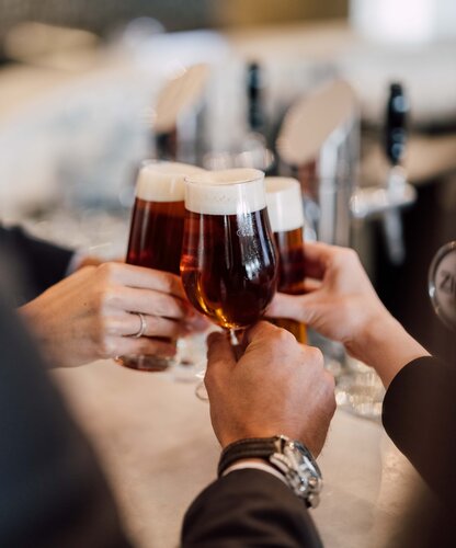 Gläser mit köstlichem Bier stoßen bei der Bierverkostung an der Hotelbar des Spa Resort Geinberg miteinander an | © Spa Resort Geinberg / Chris Perkles