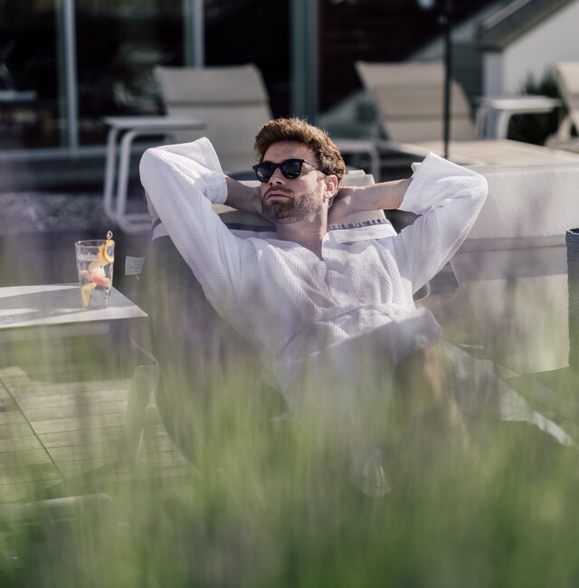 Mann entspannt auf einer Liege im Relax! Garten des Spa Resort Geinberg | © Spa Resort Geinberg / Chris Perkles