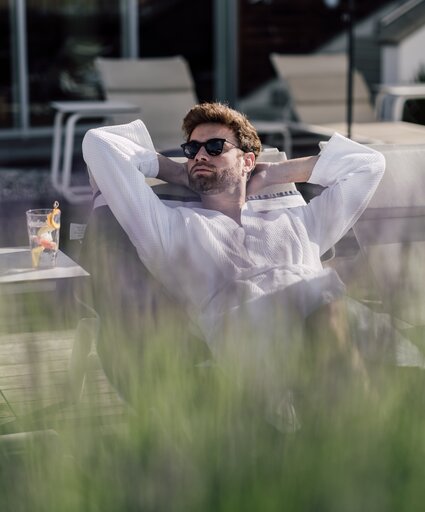 Mann entspannt auf einer Liege im Relax! Garten des Spa Resort Geinberg | © Spa Resort Geinberg / Chris Perkles