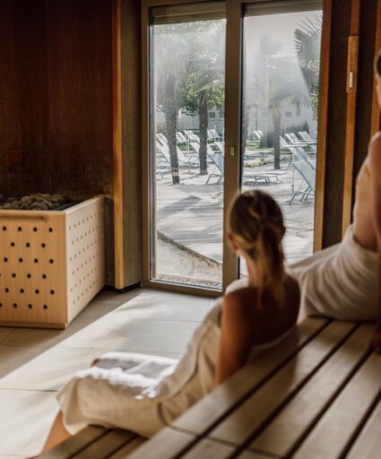 Paar genießt beim Sauna-Besuch die Aussicht auf die Strandfläche der Karibischen Saunawelt im Spa Resort Geinberg | © Spa Resort Geinberg / Chris Perkles