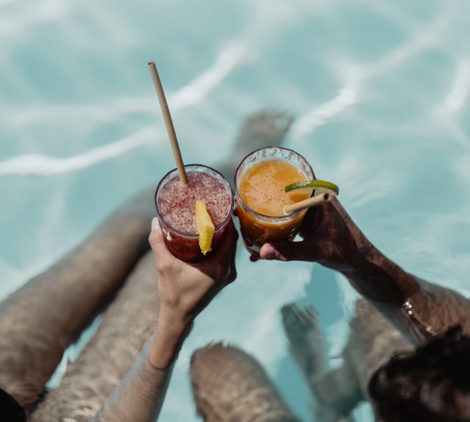 Zwei Personen genießen ihren fruchtigen Cocktail im Pool der Karibik-Lagune im Spa Resort Geinberg | © Spa Resort Geinberg / Chris Perkles