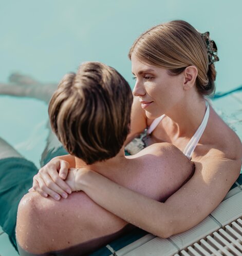 Junges Paar entspannt Arm in Arm im Salzwasser-Becken der Karibik-Lagune in der Therme im Spa Resort Geinberg | © Spa Resort Geinberg / Chris Perkles