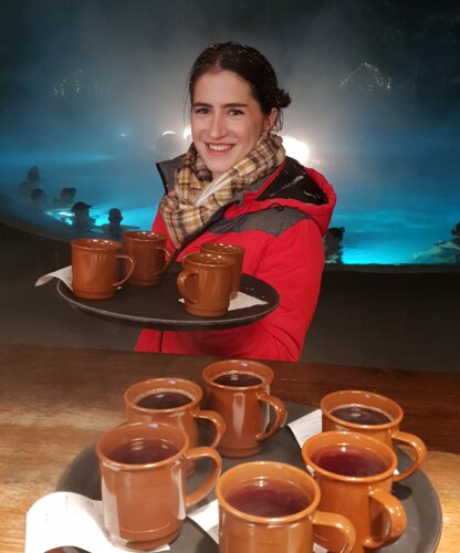 Frau in roter Jacke hält ein Tablett mit Glühwein vor der Karibik-Bar in der Therme Geinberg  | © Spa Resort Geinberg / Cornelia Schmid