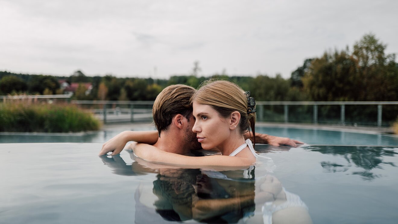 Paar entspannt bei Umarmung im Kaskaden-Becken im Spa Resort Geinberg  | © Spa Resort Geinberg / Chris Perkles