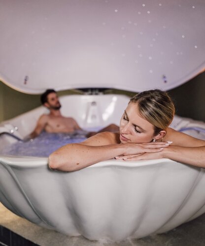 Paar entspannt in der romantischen Floating-Muschel des Spa Resort Geinberg | © Spa Resort Geinberg / Chris Perkles